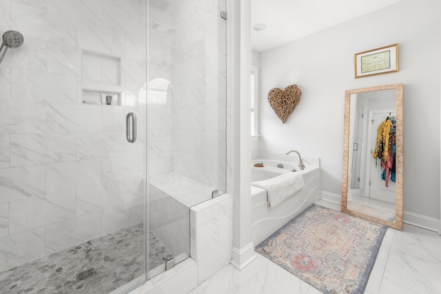 bathroom featuring baseboards, a garden tub, marble finish floor, and a shower stall