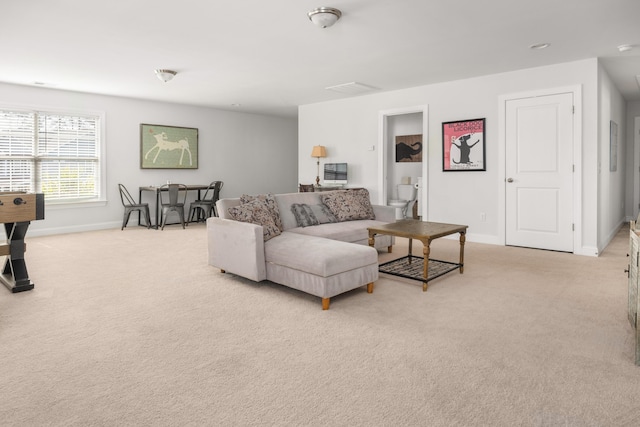 living area featuring light colored carpet and baseboards