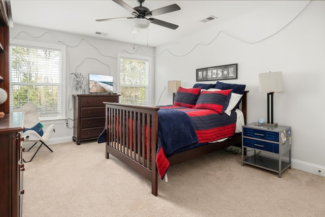 bedroom with visible vents, baseboards, light colored carpet, and a ceiling fan