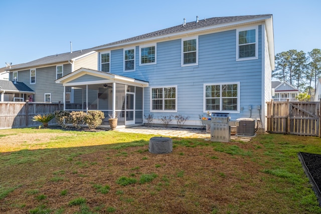 back of property with a lawn, a fenced backyard, and a sunroom