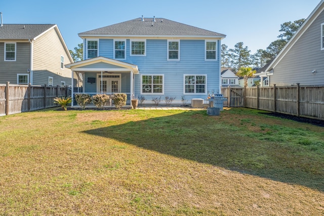 rear view of house with cooling unit, a fenced backyard, a lawn, and ceiling fan