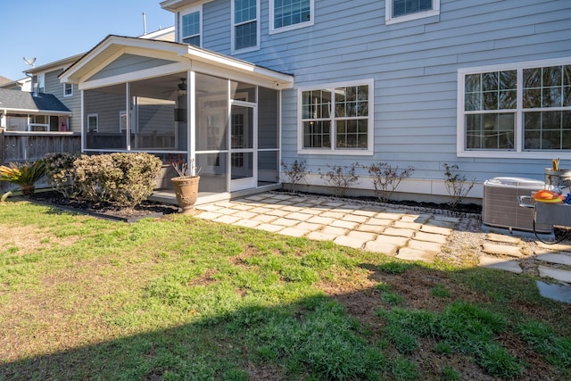 back of house featuring a yard, a patio, central AC unit, and a sunroom