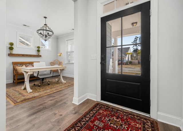 entrance foyer with visible vents, baseboards, dark wood-type flooring, crown molding, and a notable chandelier