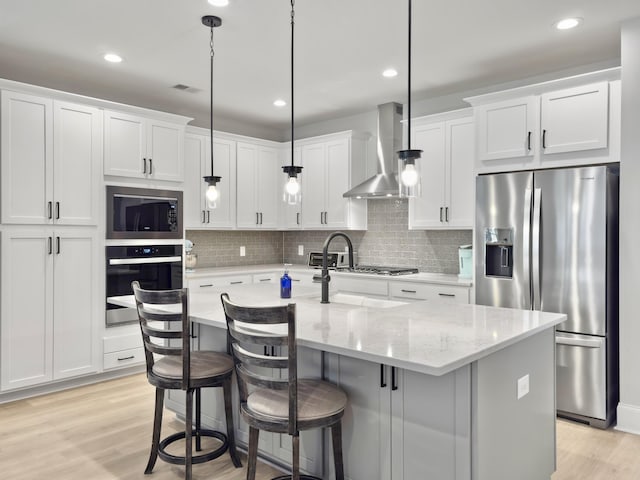 kitchen with white cabinetry, stainless steel fridge with ice dispenser, hanging light fixtures, black oven, and wall chimney range hood