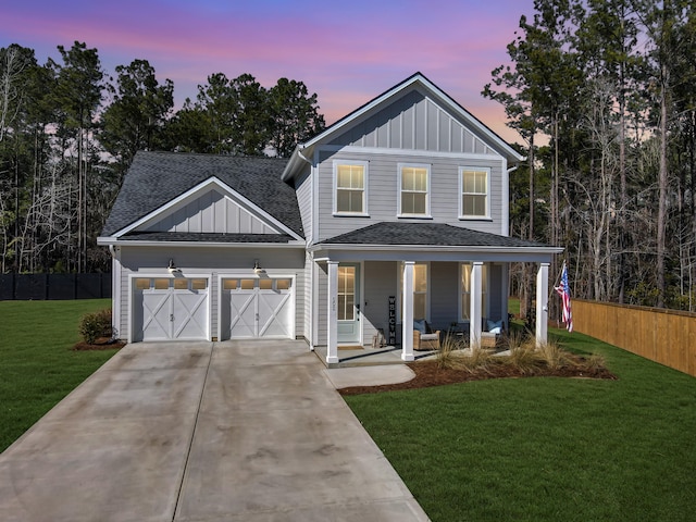 view of front of house with a garage, a yard, and covered porch