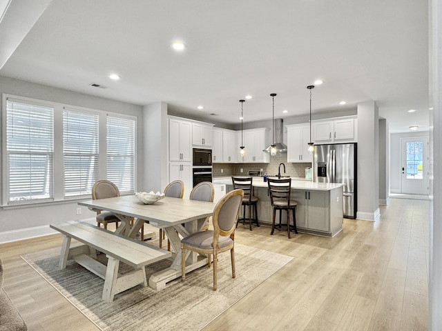 dining room with sink and light wood-type flooring