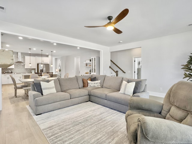 living room featuring light hardwood / wood-style floors and ceiling fan