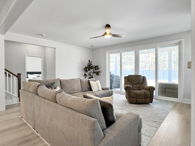 living room featuring ceiling fan, a healthy amount of sunlight, and light wood-type flooring