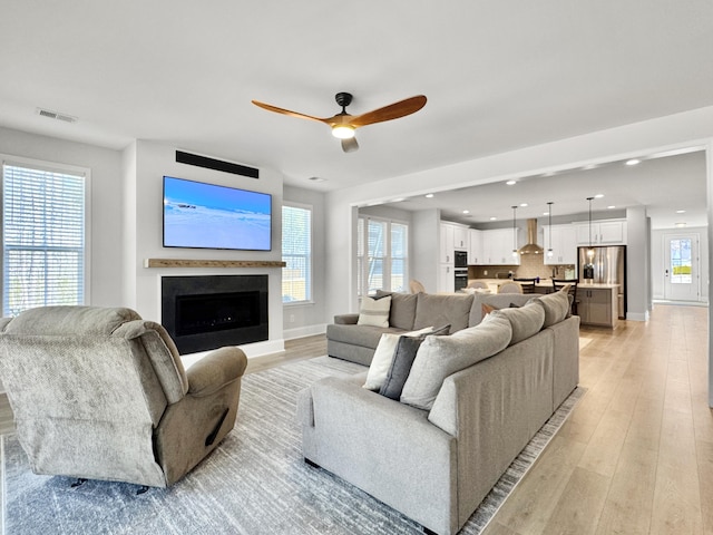 living room featuring ceiling fan and light hardwood / wood-style flooring