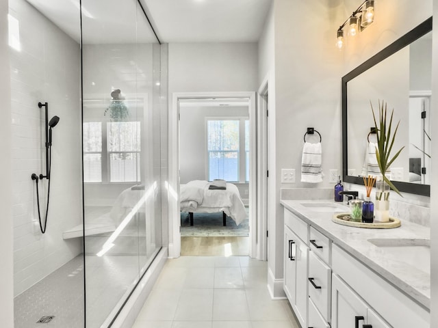 bathroom with a tile shower, vanity, and tile patterned floors