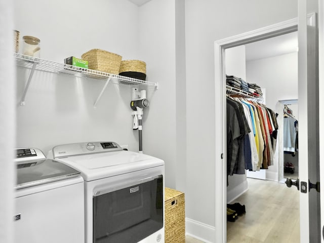 washroom with separate washer and dryer and light wood-type flooring