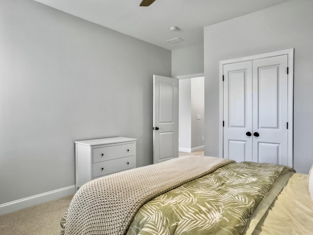 bedroom with light carpet, ceiling fan, and a closet