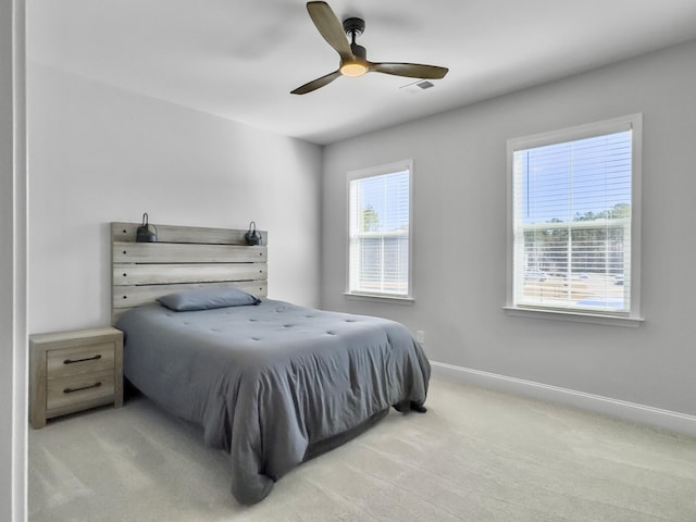 bedroom with multiple windows, light colored carpet, and ceiling fan