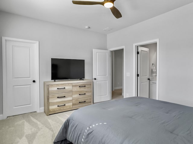 bedroom with ceiling fan, ensuite bathroom, and light carpet