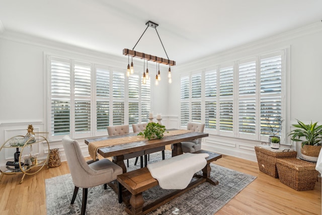 dining space with crown molding and light wood-type flooring