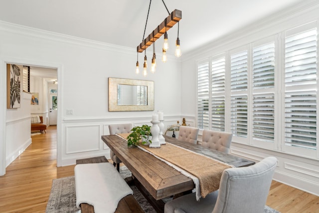 dining space with a chandelier, crown molding, and light hardwood / wood-style floors