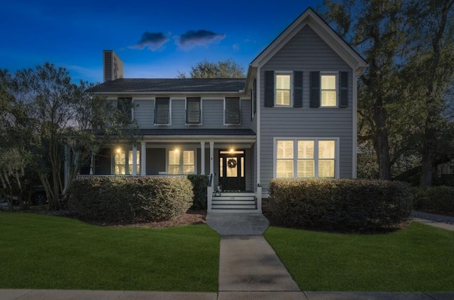 view of front of property featuring a lawn and a porch