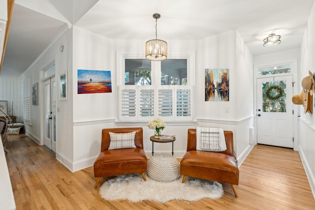 entrance foyer with a chandelier, crown molding, and light hardwood / wood-style flooring