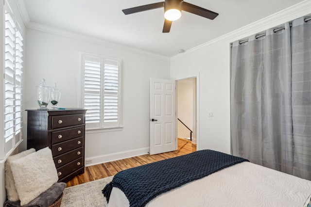 bedroom with light wood-type flooring, ceiling fan, and crown molding