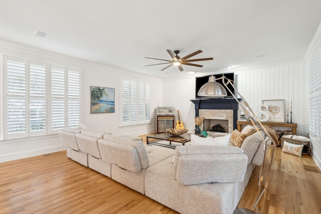 living room featuring a fireplace, hardwood / wood-style floors, plenty of natural light, and ornamental molding