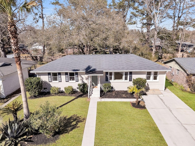 ranch-style home featuring a front yard, concrete driveway, and roof with shingles