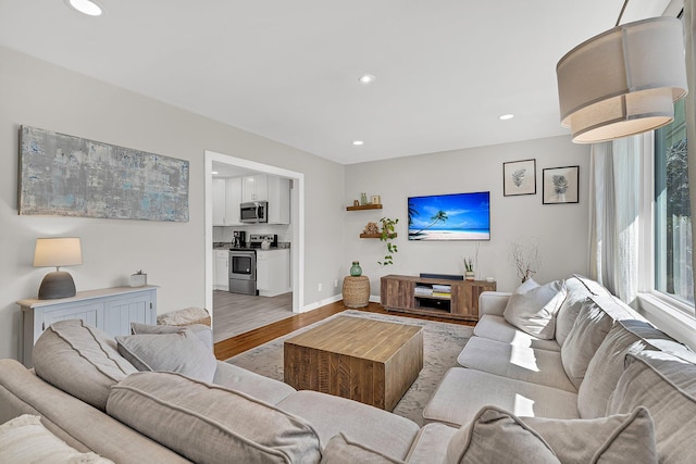 living area featuring recessed lighting, baseboards, and light wood finished floors