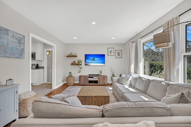 living area featuring recessed lighting, baseboards, and wood finished floors