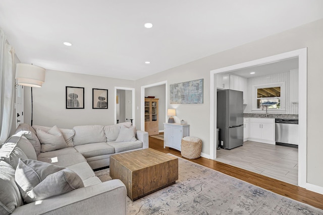 living area featuring recessed lighting, light wood-style floors, and baseboards