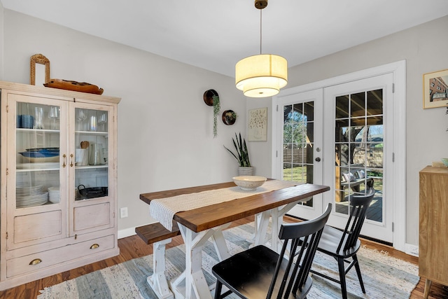 dining area with french doors, baseboards, and wood finished floors