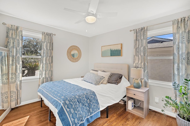 bedroom featuring ceiling fan, baseboards, and wood finished floors