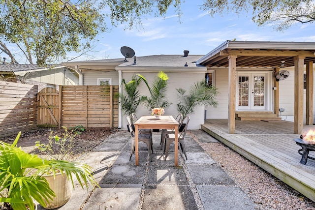 view of patio with a gate, french doors, a wooden deck, and fence