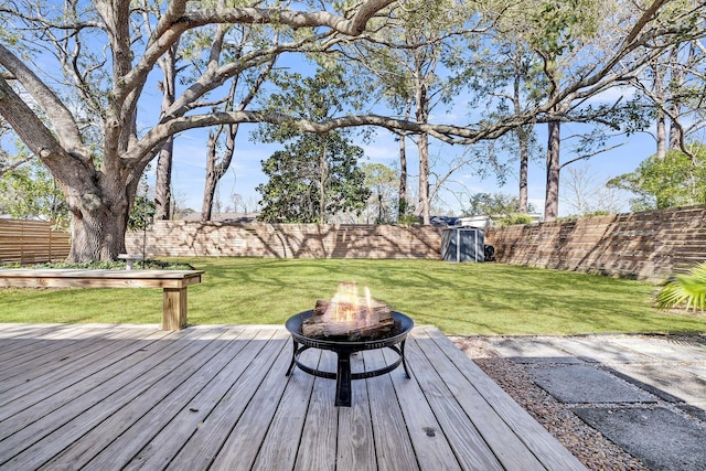 deck featuring a yard, a fenced backyard, and an outdoor fire pit