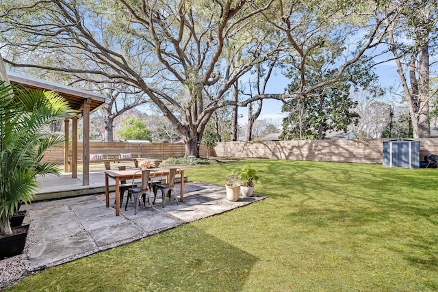 view of yard featuring a deck, a patio, and a fenced backyard