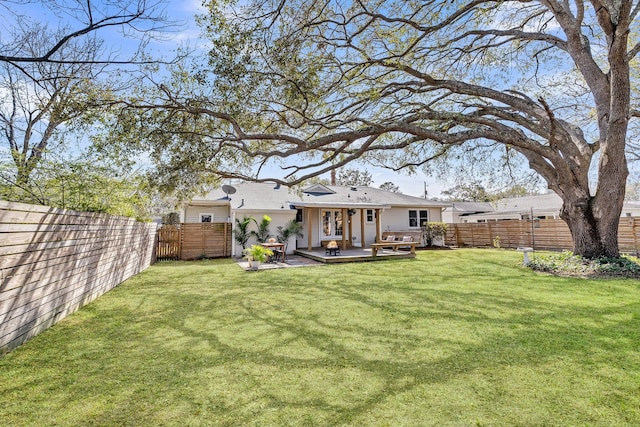 back of house featuring a deck, a yard, and a fenced backyard