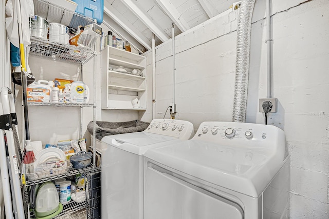 washroom with washer and dryer, laundry area, and concrete block wall