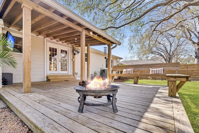 wooden deck with french doors, fence, and an outdoor fire pit