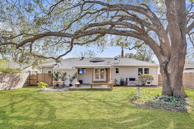 back of property featuring french doors, a lawn, a deck, and fence