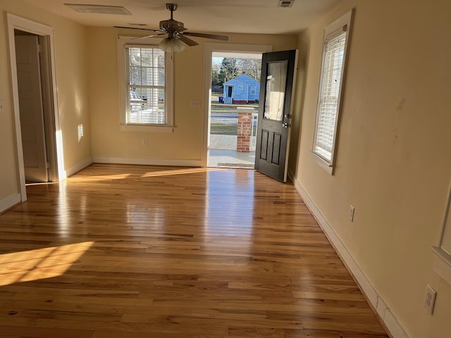 entrance foyer with baseboards, a ceiling fan, visible vents, and light wood-style floors