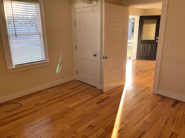 unfurnished bedroom with light wood-style floors, baseboards, and a closet