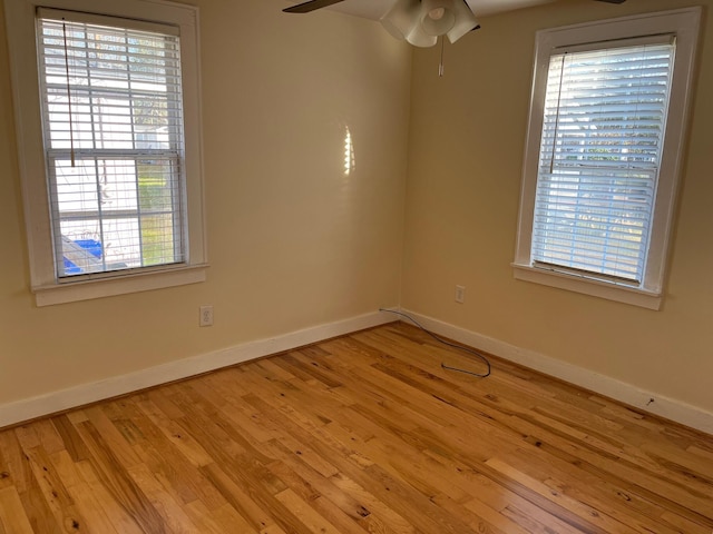 unfurnished room with ceiling fan, baseboards, and wood finished floors