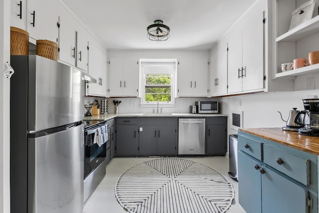 kitchen featuring gray cabinets, appliances with stainless steel finishes, butcher block counters, sink, and white cabinets