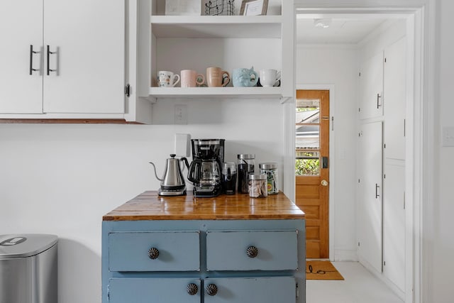 bar with white cabinetry, blue cabinetry, and butcher block countertops