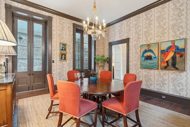 dining space with french doors, ornamental molding, a chandelier, and hardwood / wood-style floors