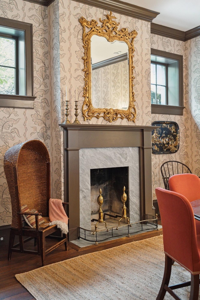 living area with a premium fireplace, ornamental molding, and hardwood / wood-style flooring