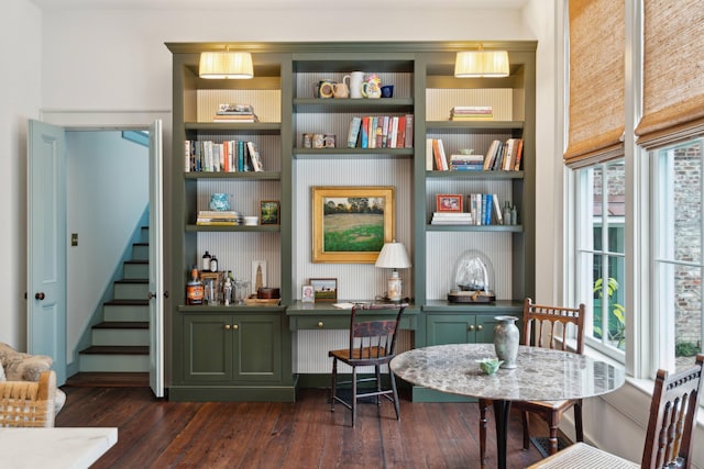 sitting room with built in shelves and dark hardwood / wood-style flooring