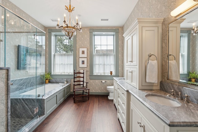 full bathroom with wood-type flooring, vanity, shower with separate bathtub, toilet, and a notable chandelier