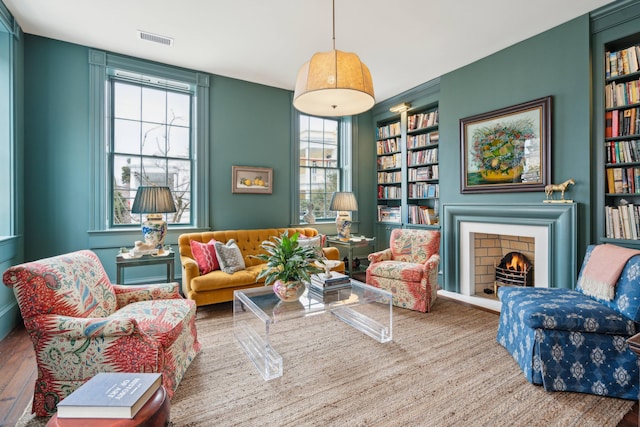 living area with built in features and hardwood / wood-style floors