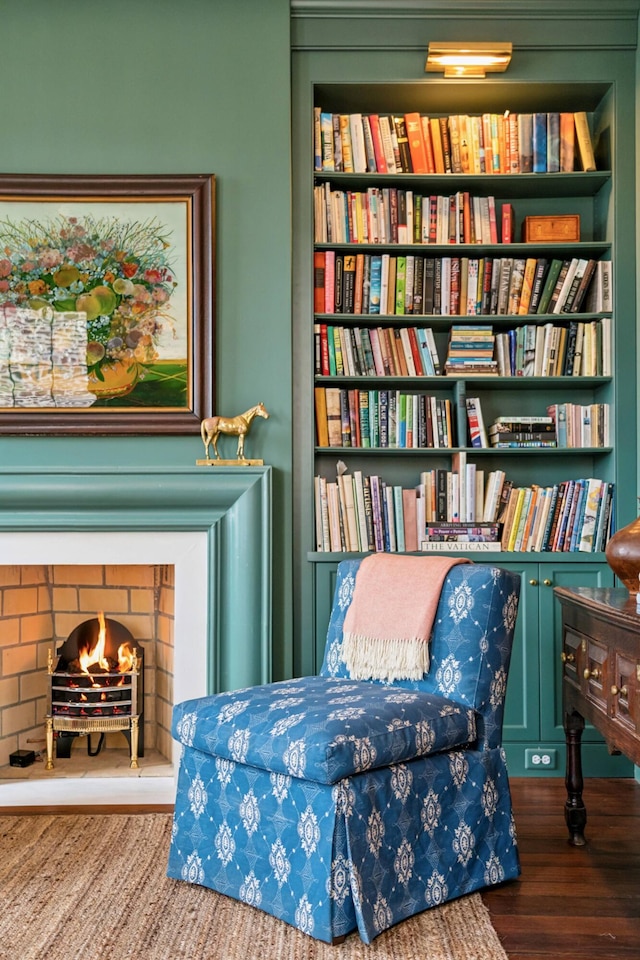 sitting room featuring hardwood / wood-style flooring and built in shelves