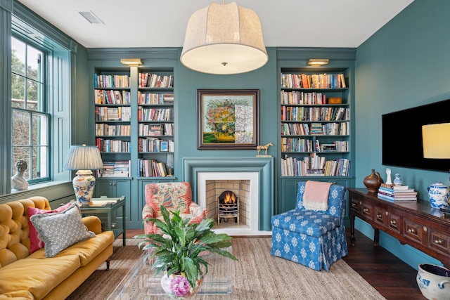 sitting room featuring built in features and dark hardwood / wood-style floors