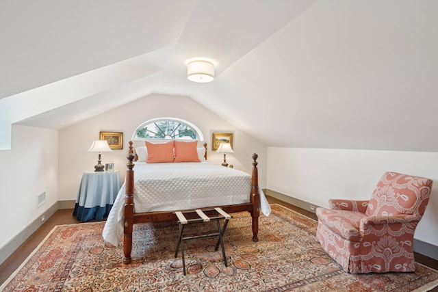 bedroom with hardwood / wood-style floors and lofted ceiling